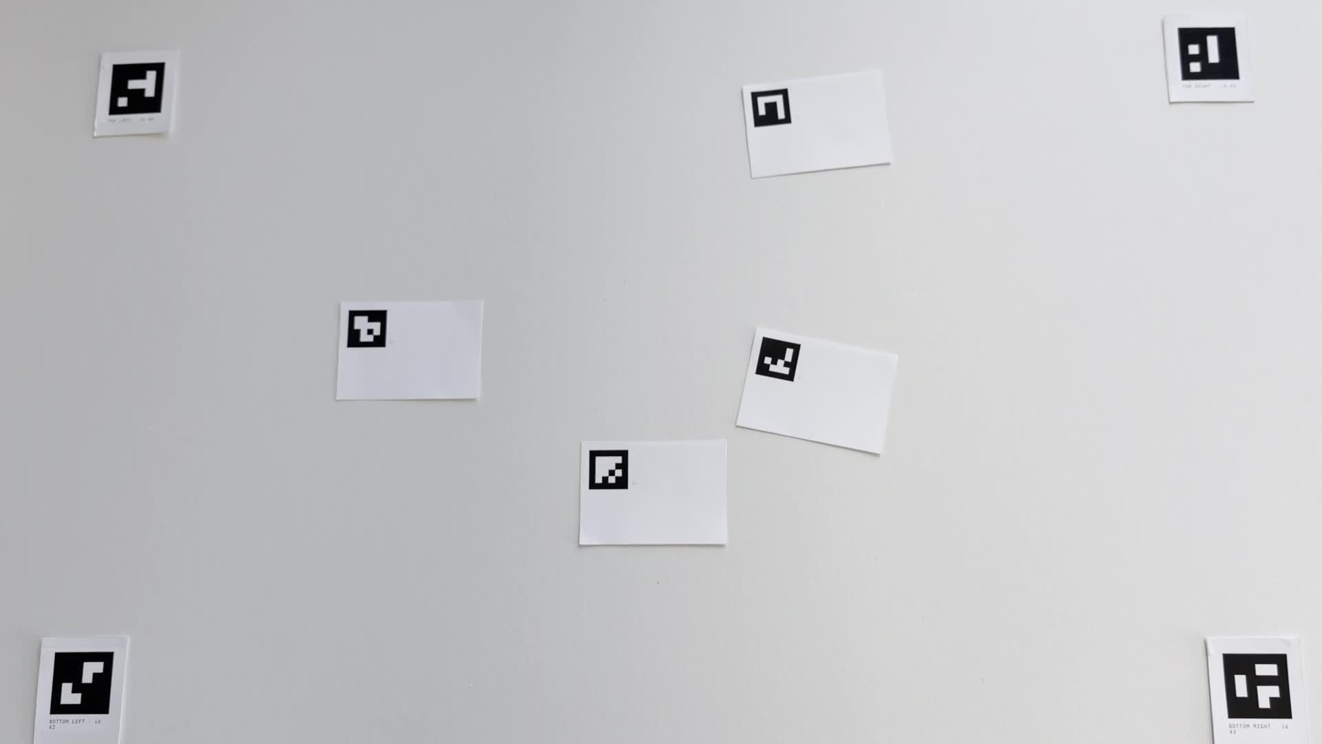 The table from above, with four corner markers and blank cards on a paper field.